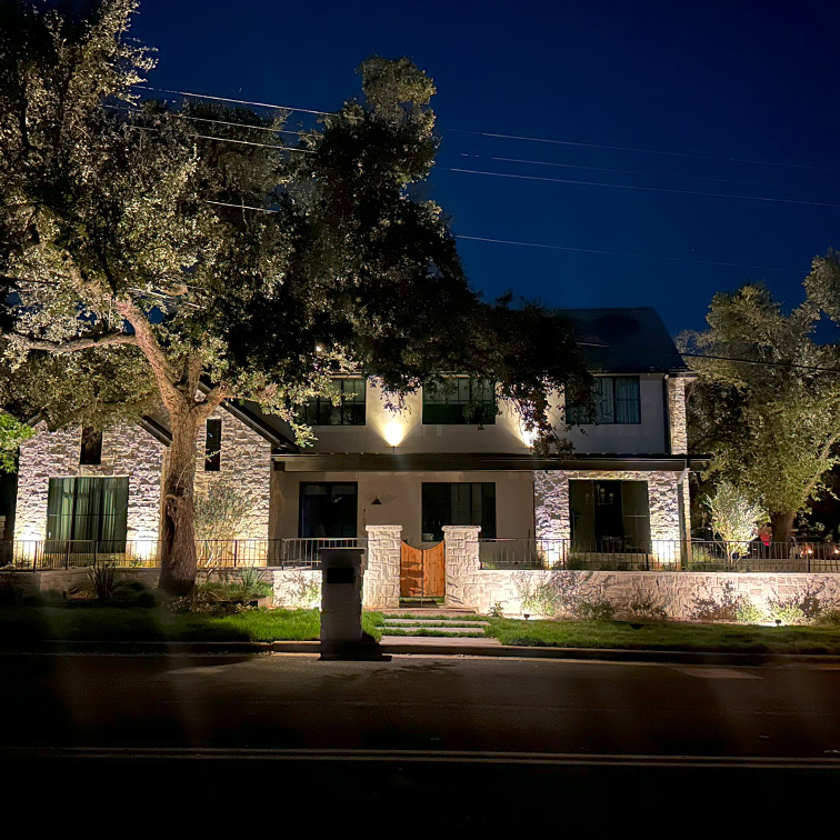 Home decorated with outdoor Christmas lights and illuminated yard decorations