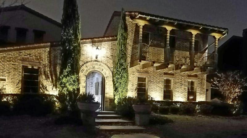 The brickwork of a south Texas home can be seen at night by the exterior lighting