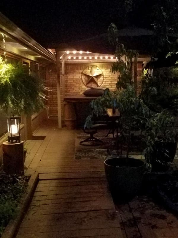 backyard patio lit up with outdoor lighting