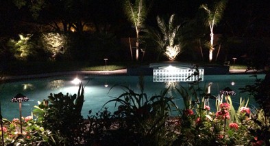 backyard pool with outdoor lighting