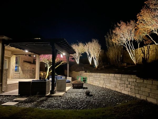 back patio and pergola with outdoor lighting
